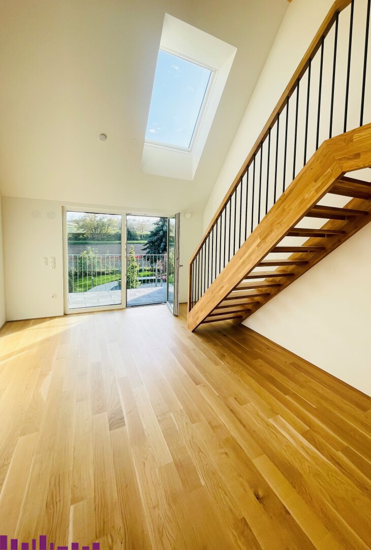 Wohnzimmer mit Holzfußboden und Treppe zur Gallerie